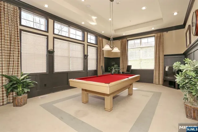 a room with pool table and windows