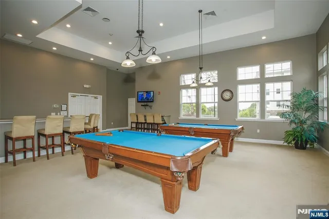 a room with pool table and windows