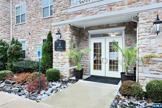 front view of a brick house with potted plants