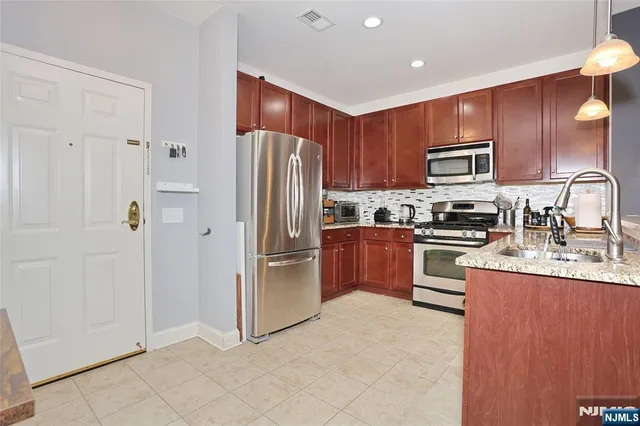 a kitchen with stainless steel appliances granite countertop a refrigerator and a stove top oven