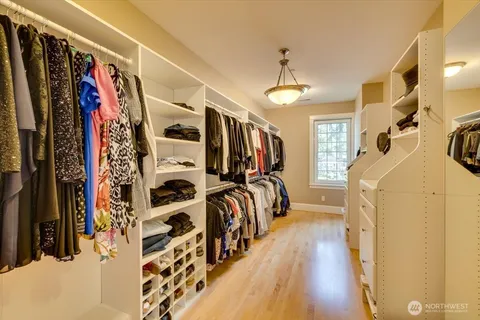a view of walk in closet with clothes and shoes