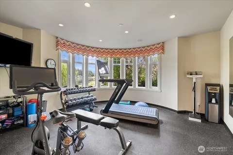 a living room with furniture a flat screen tv and a floor to ceiling window