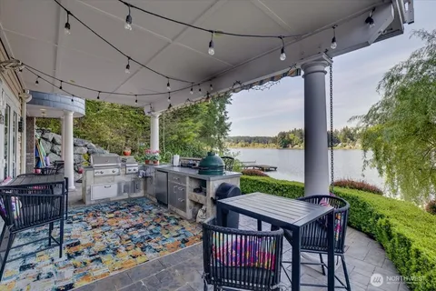 a view of a patio with a table chairs and a yard