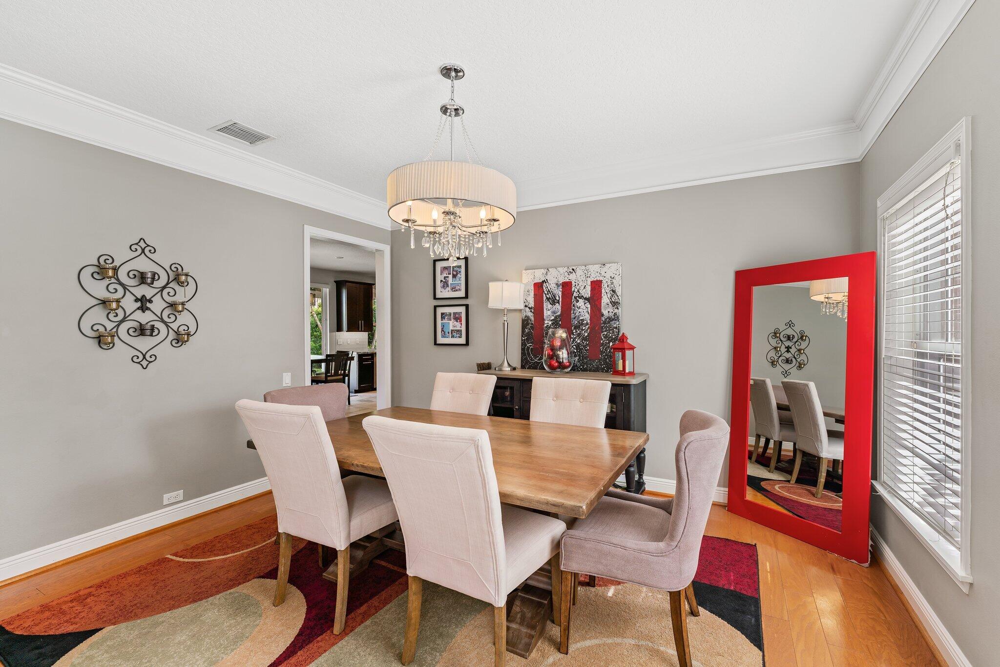 203 Anhinga Lane Jupiter, FL 33458 - Photo 18 of 63 a view of a dining room with furniture wooden floor and a chandelier