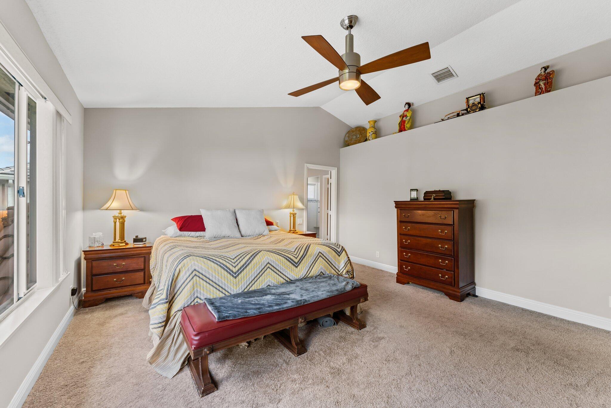 203 Anhinga Lane Jupiter, FL 33458 - Photo 26 of 63 a bedroom with furniture and a ceiling fan