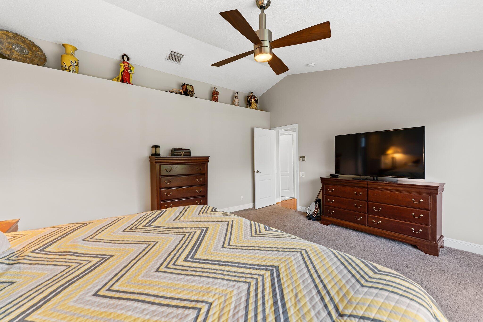 203 Anhinga Lane Jupiter, FL 33458 - Photo 27 of 63 a bedroom with a bed and a flat screen tv