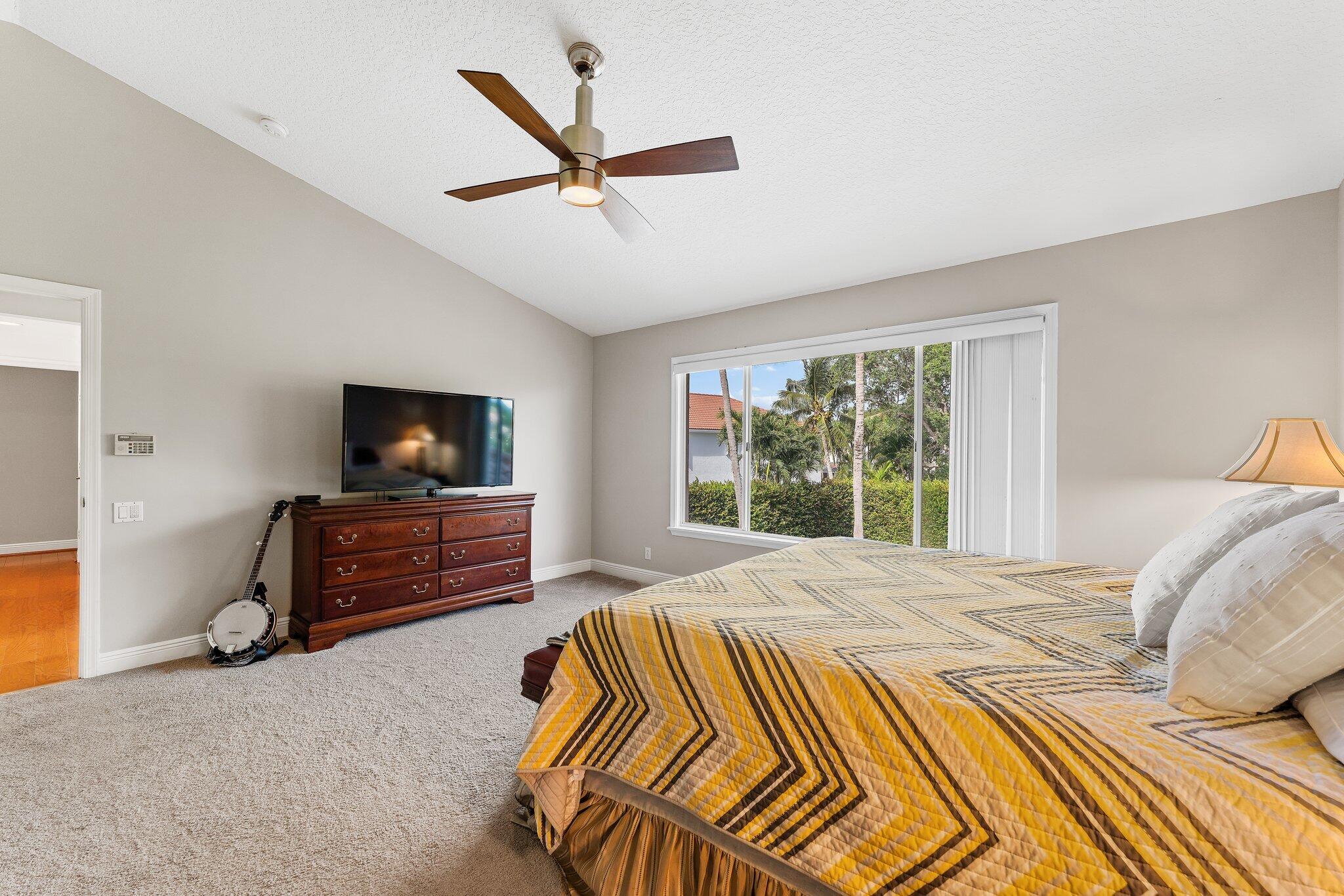 203 Anhinga Lane Jupiter, FL 33458 - Photo 28 of 63 a bedroom with a bed and a television in it