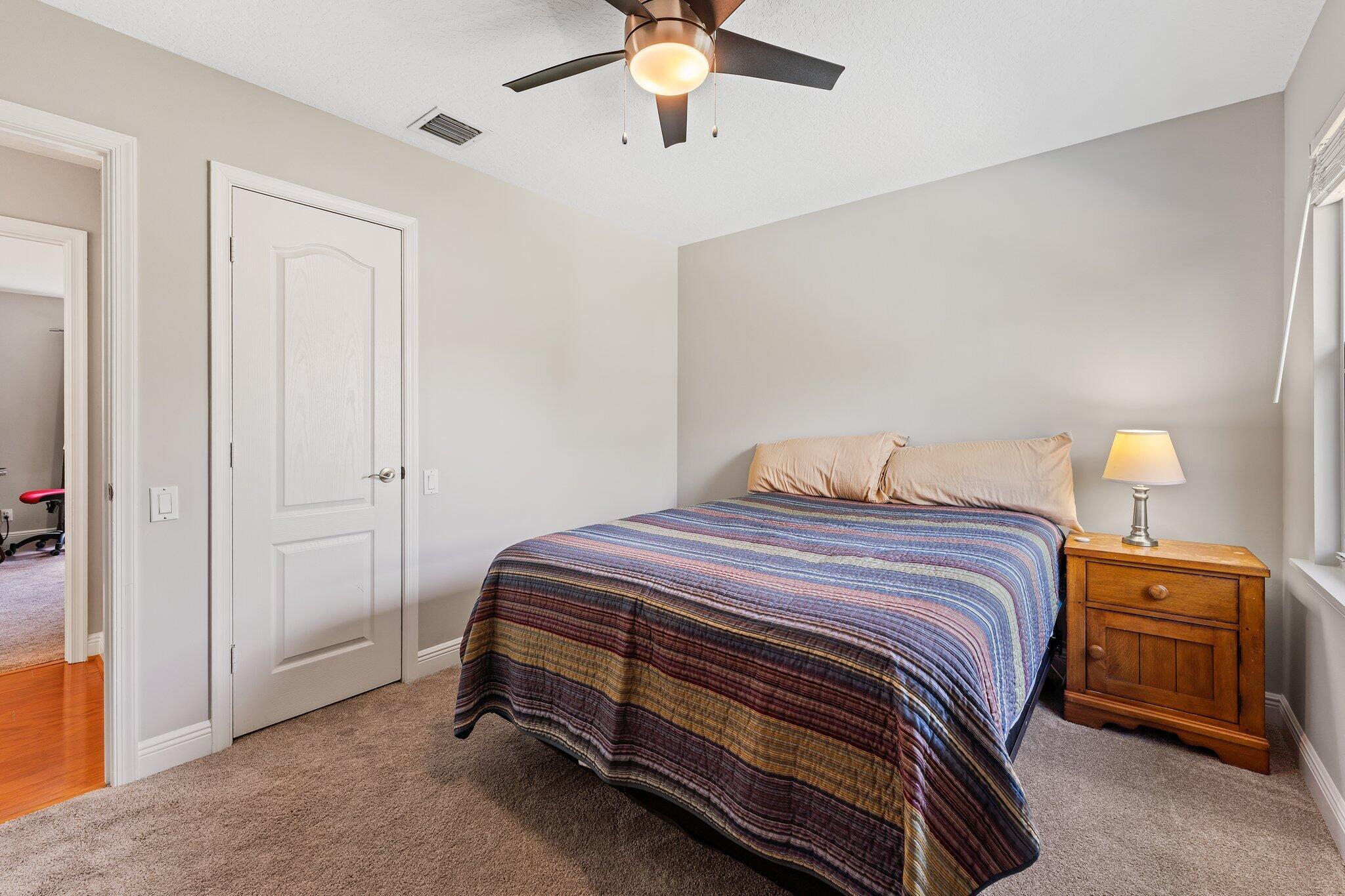 203 Anhinga Lane Jupiter, FL 33458 - Photo 42 of 63 a bedroom with a bed and a chandelier