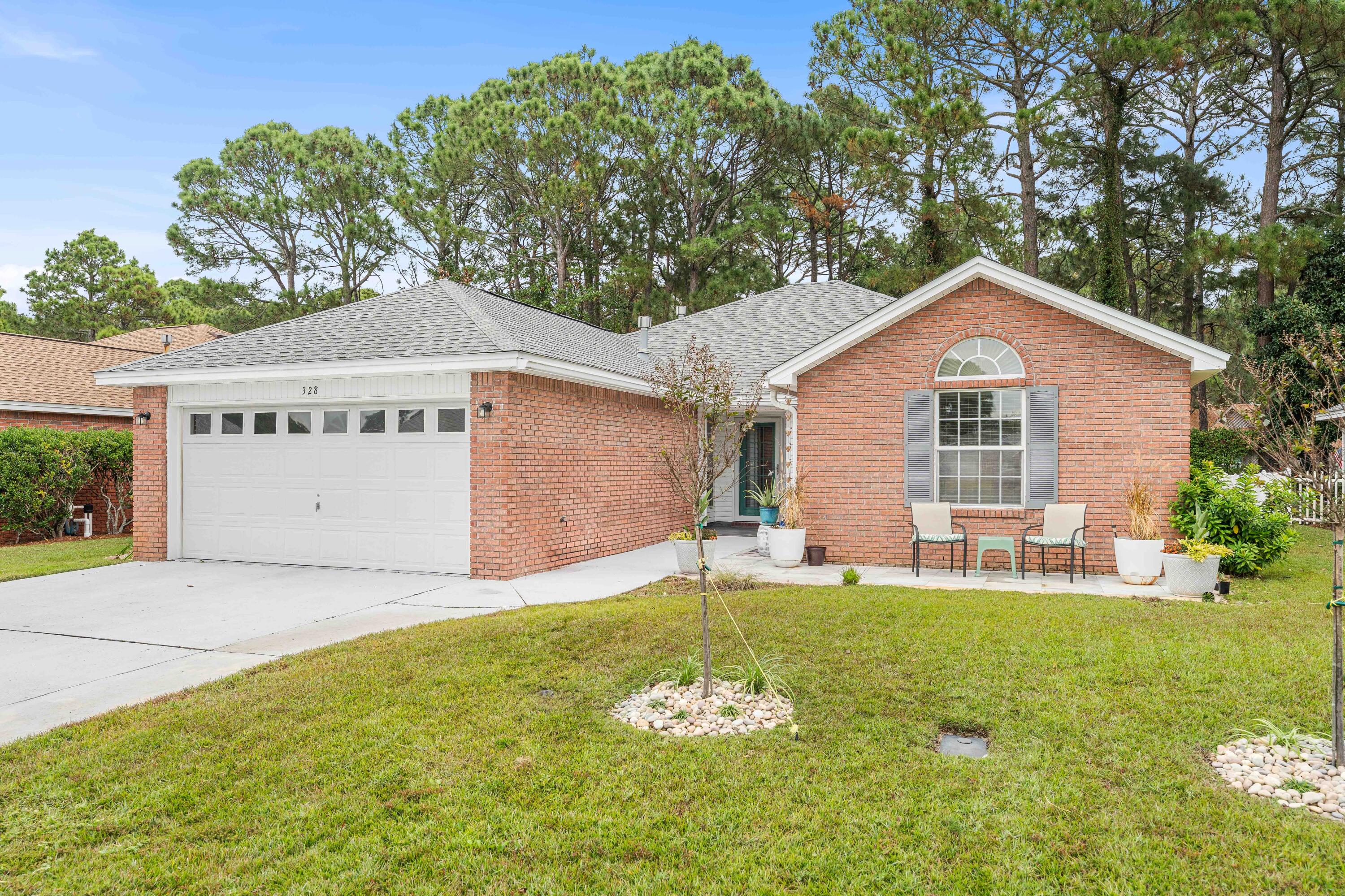 328 Bay Tree Drive Miramar Beach, FL 32550 - Photo 1 of 49 a front view of a house with a yard and garage