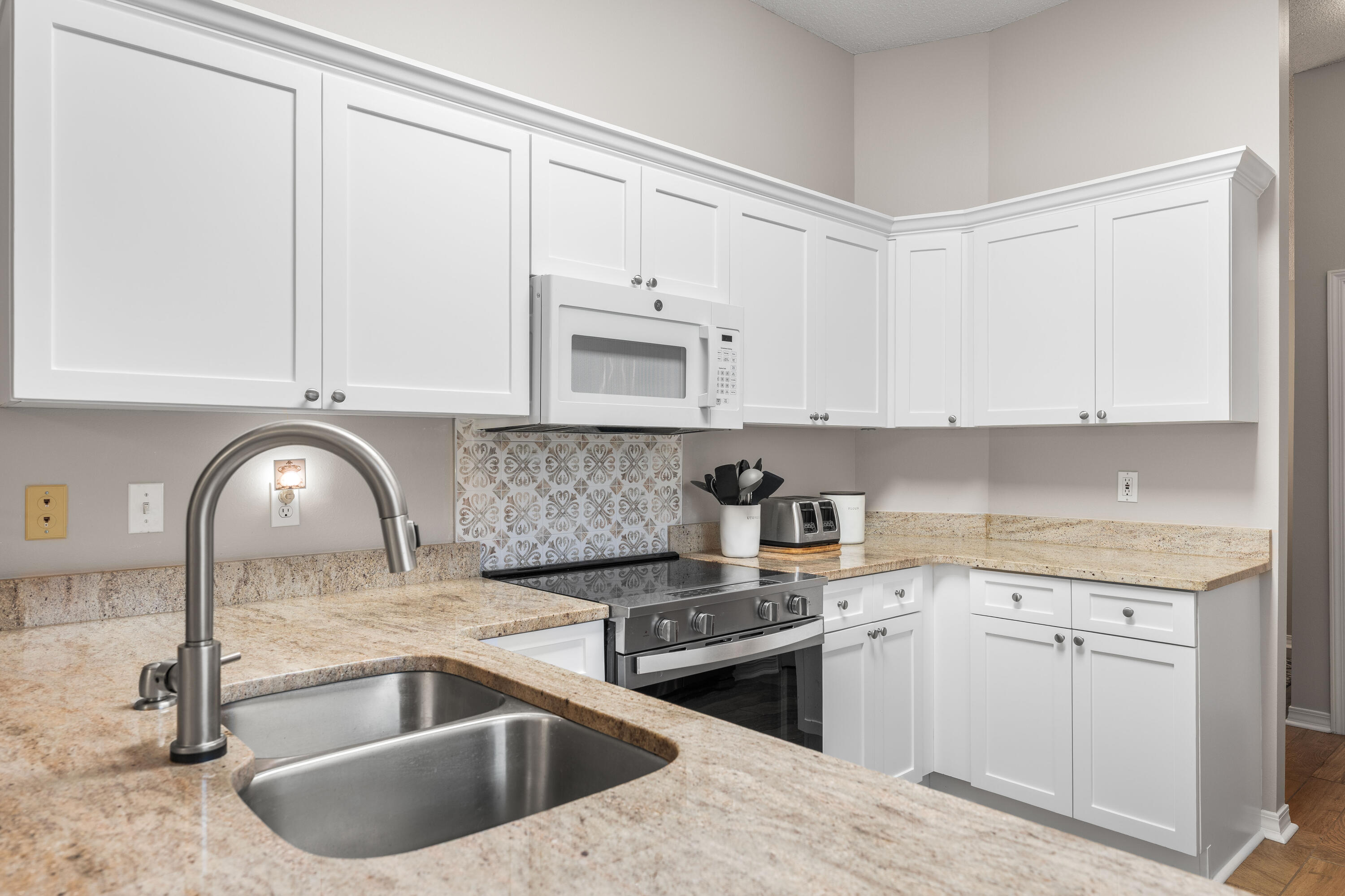328 Bay Tree Drive Miramar Beach, FL 32550 - Photo 15 of 49 a kitchen with granite countertop a sink a stove and cabinets