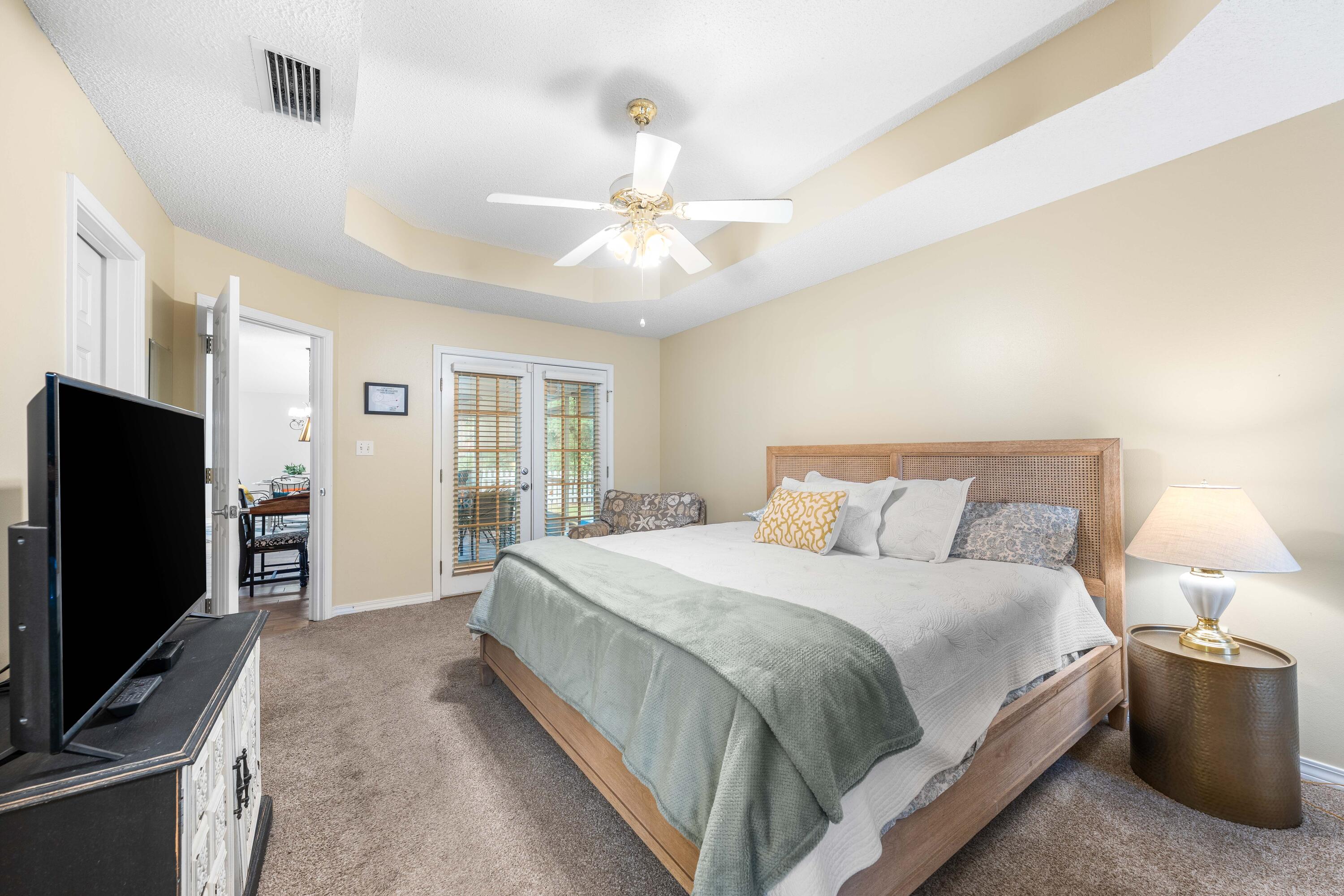 328 Bay Tree Drive Miramar Beach, FL 32550 - Photo 22 of 49 a bedroom with a bed flat screen tv and a chandelier