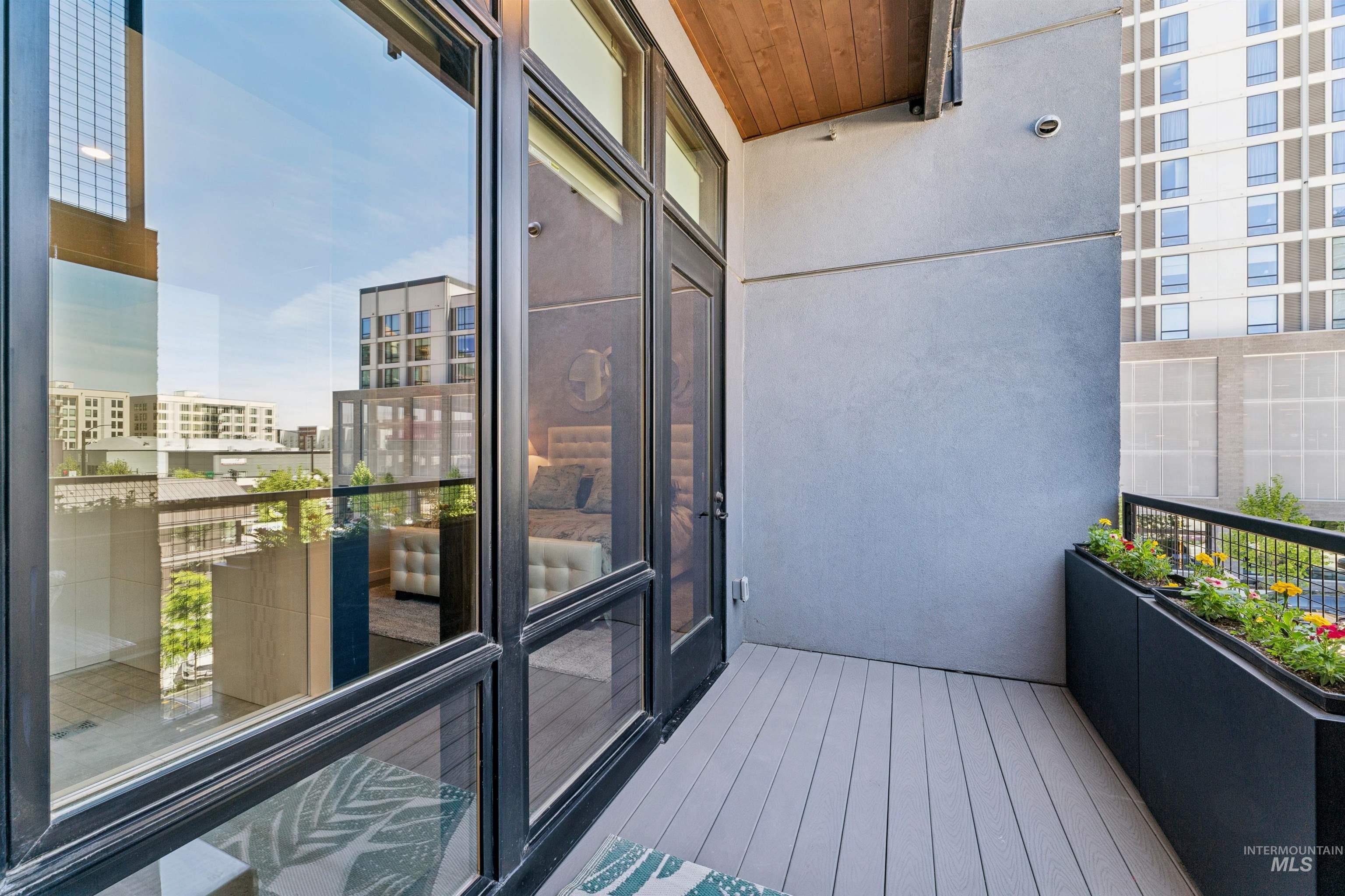 119 South 10th Street, Unit 307 Boise, ID 83702 - Photo 29 of 47 Private balcony featuring composite decking, a built-in planter with foliage, and a wood-paneled ceiling accent