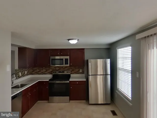 a kitchen with a refrigerator and a stove top oven