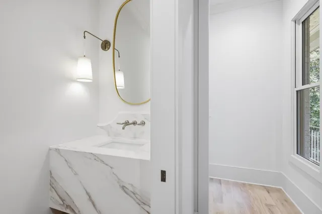 a bathroom with a sink and mirror with window