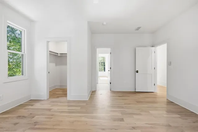 an empty room with wooden floor and windows