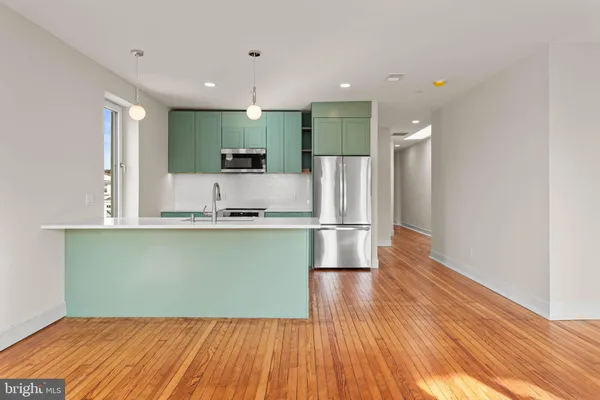 a kitchen with stainless steel appliances granite countertop a refrigerator a stove and a sink