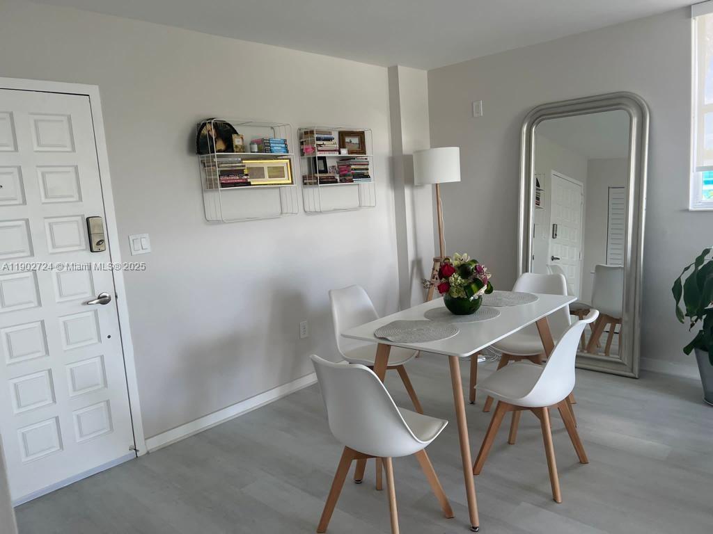 650 Northeast 64th Street, Unit G508 Miami, FL 33138 - Photo 3 of 11 a view of a workspace with furniture and wooden floor