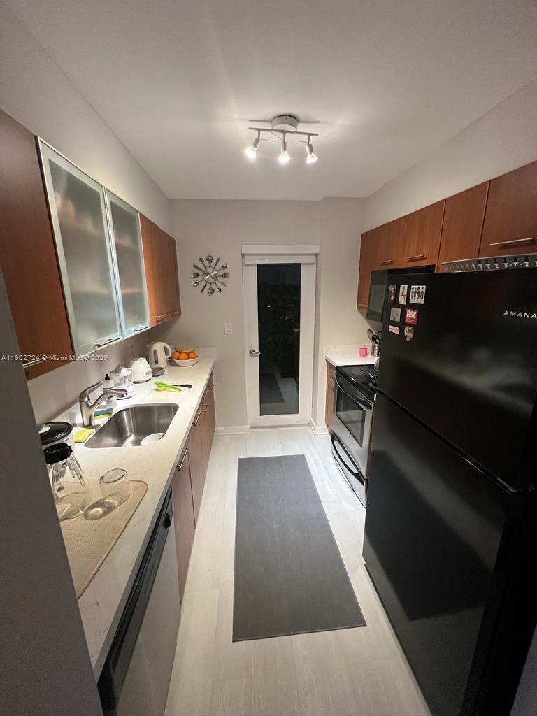 650 Northeast 64th Street, Unit G508 Miami, FL 33138 - Photo 4 of 11 a kitchen with stainless steel appliances kitchen island granite countertop a refrigerator stove and sink