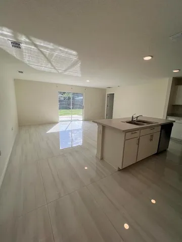 an empty room with wooden floor and a glass door