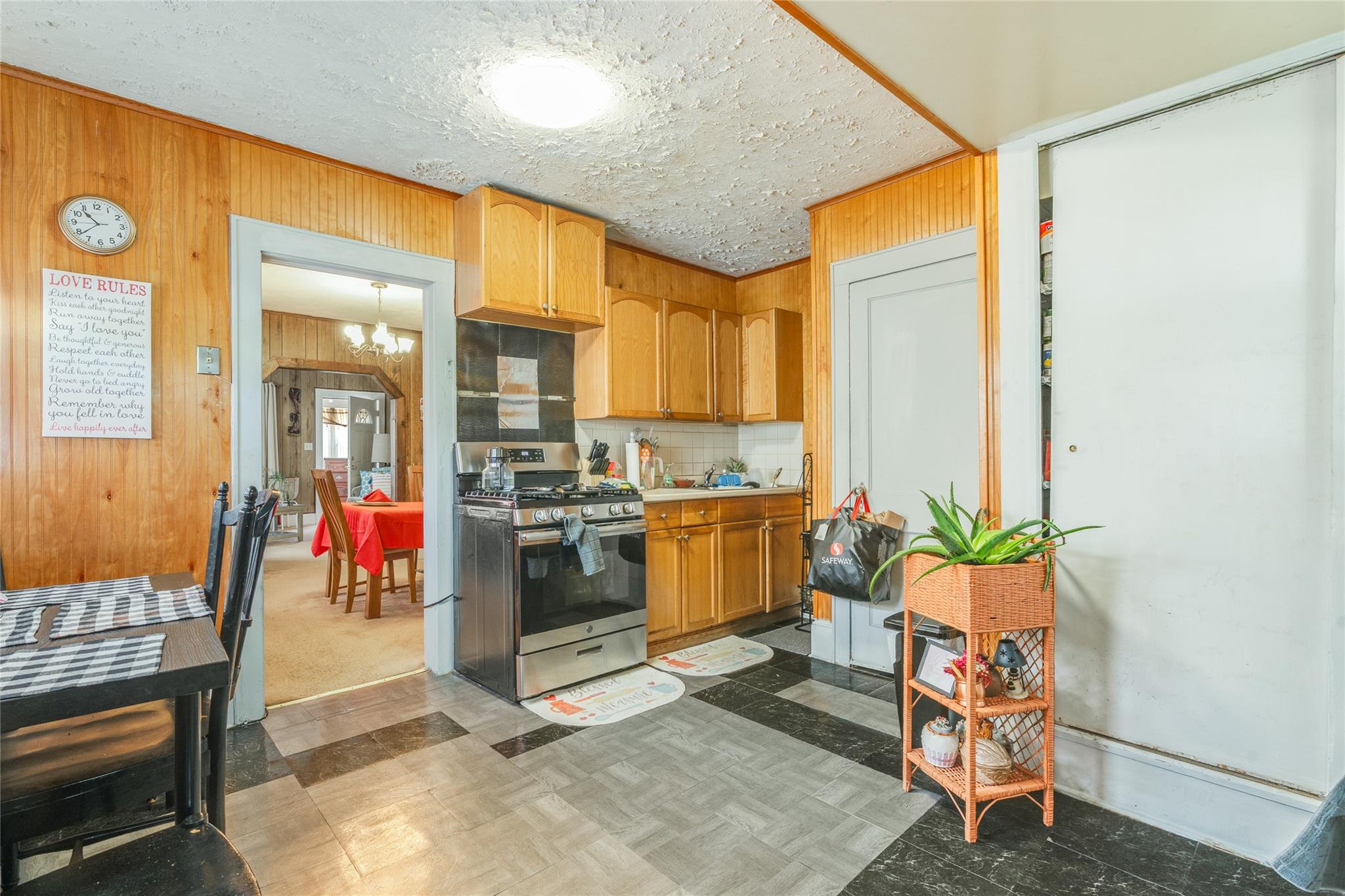17 Lawrence Road Poughkeepsie, NY 12601 - Photo 3 of 17 Kitchen featuring an inviting chandelier, wood walls, decorative backsplash, gas range, and light countertops