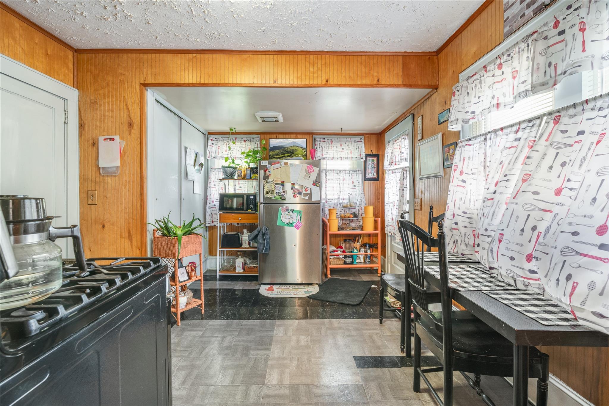 17 Lawrence Road Poughkeepsie, NY 12601 - Photo 4 of 17 Kitchen featuring wooden walls, a textured ceiling, ornamental molding, and black appliances