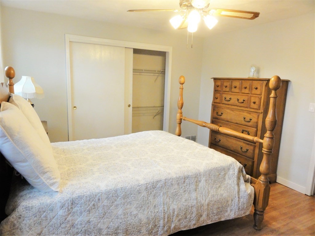 1955 Middlesex Street, Unit E Lowell, MA 01851 - Photo 16 of 20 a bedroom with a bed and a chandelier