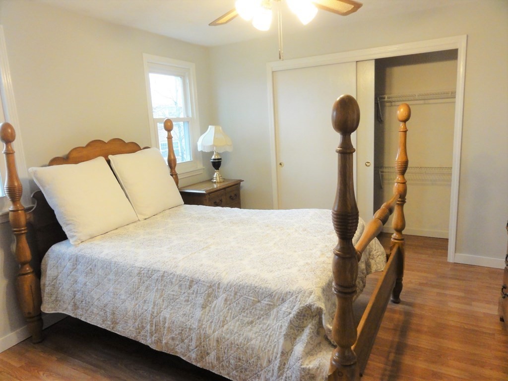 1955 Middlesex Street, Unit E Lowell, MA 01851 - Photo 17 of 20 a bedroom with a bed and a chandelier