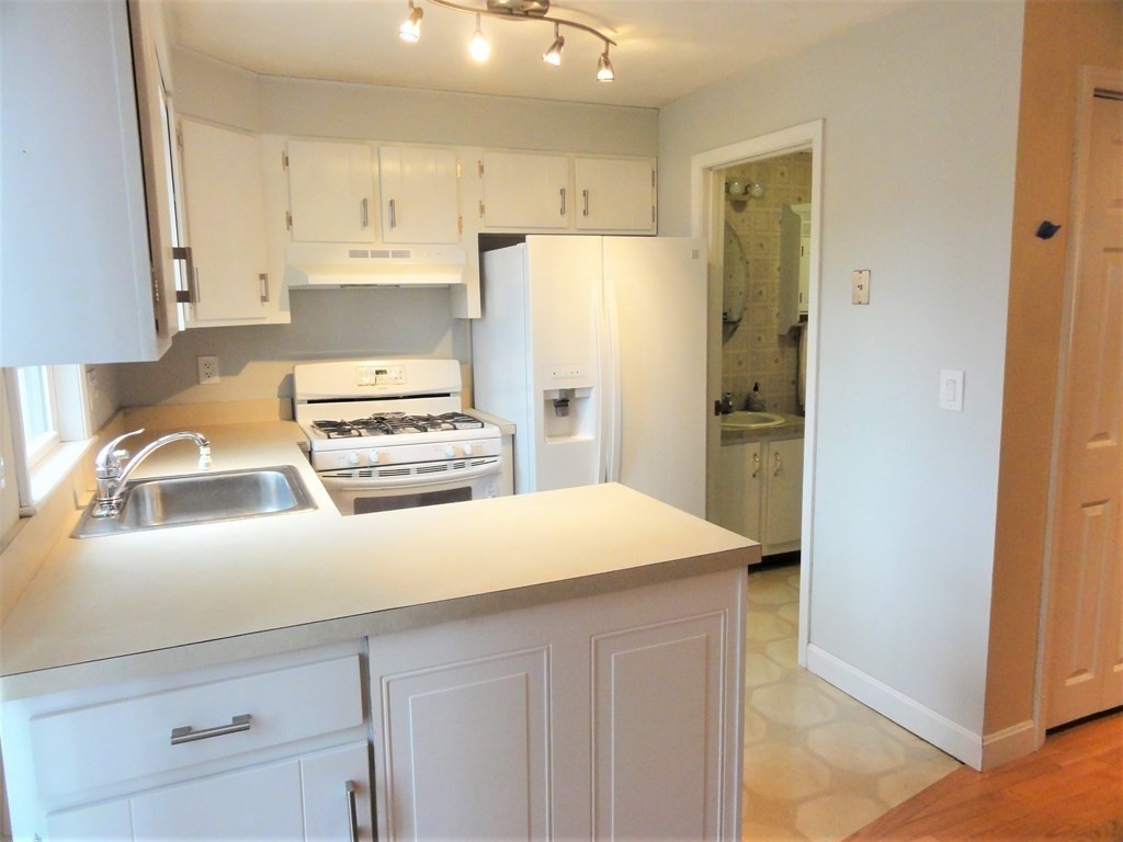 1955 Middlesex Street, Unit E Lowell, MA 01851 - Photo 3 of 20 a kitchen with a refrigerator and a sink