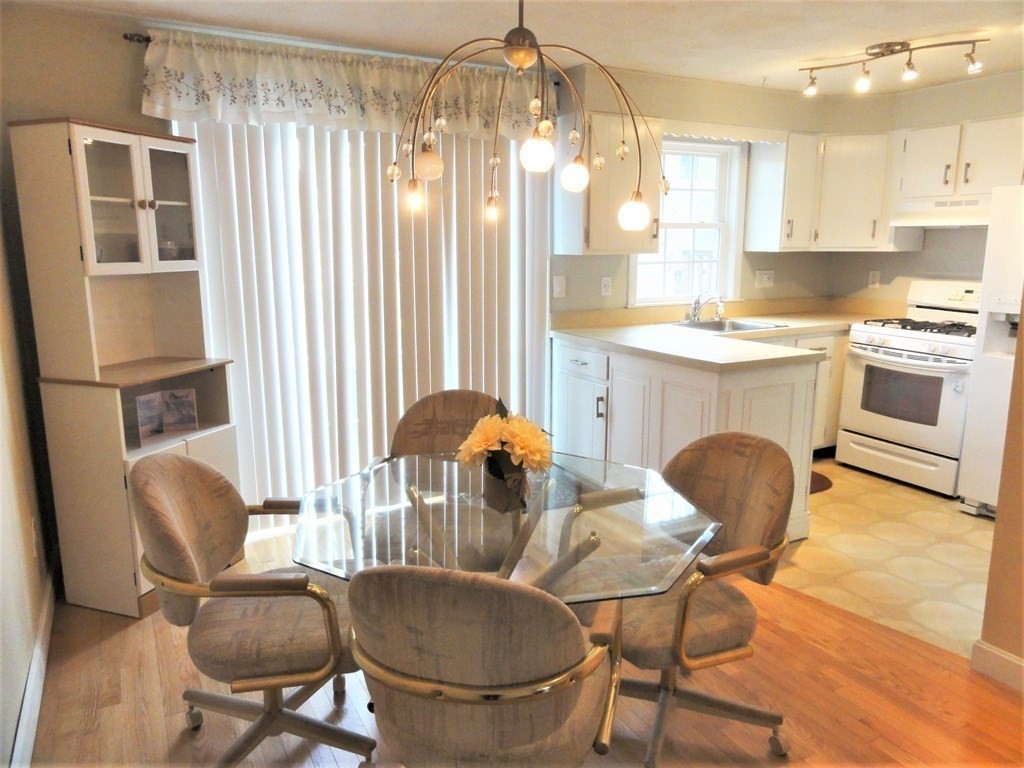 1955 Middlesex Street, Unit E Lowell, MA 01851 - Photo 5 of 20 a kitchen with furniture and a chandelier