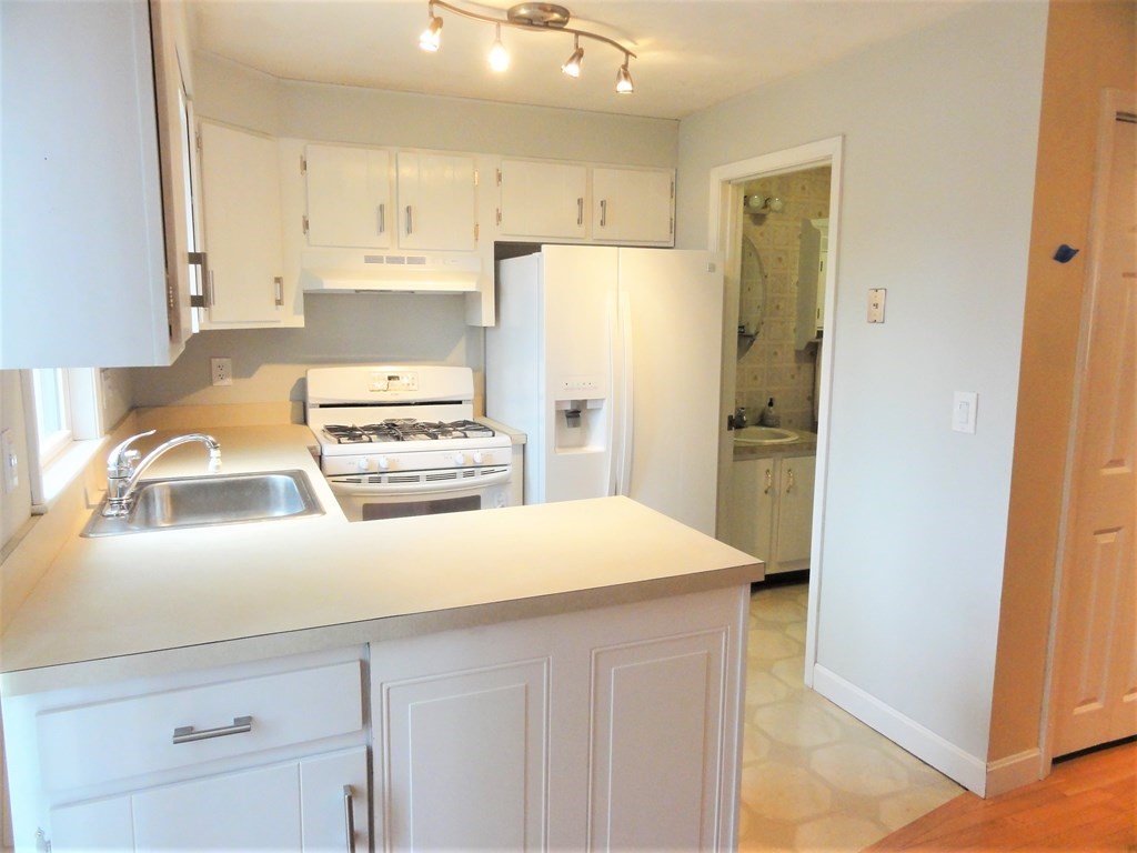 1955 Middlesex Street, Unit E Lowell, MA 01851 - Photo 7 of 20 a kitchen with a refrigerator and a sink