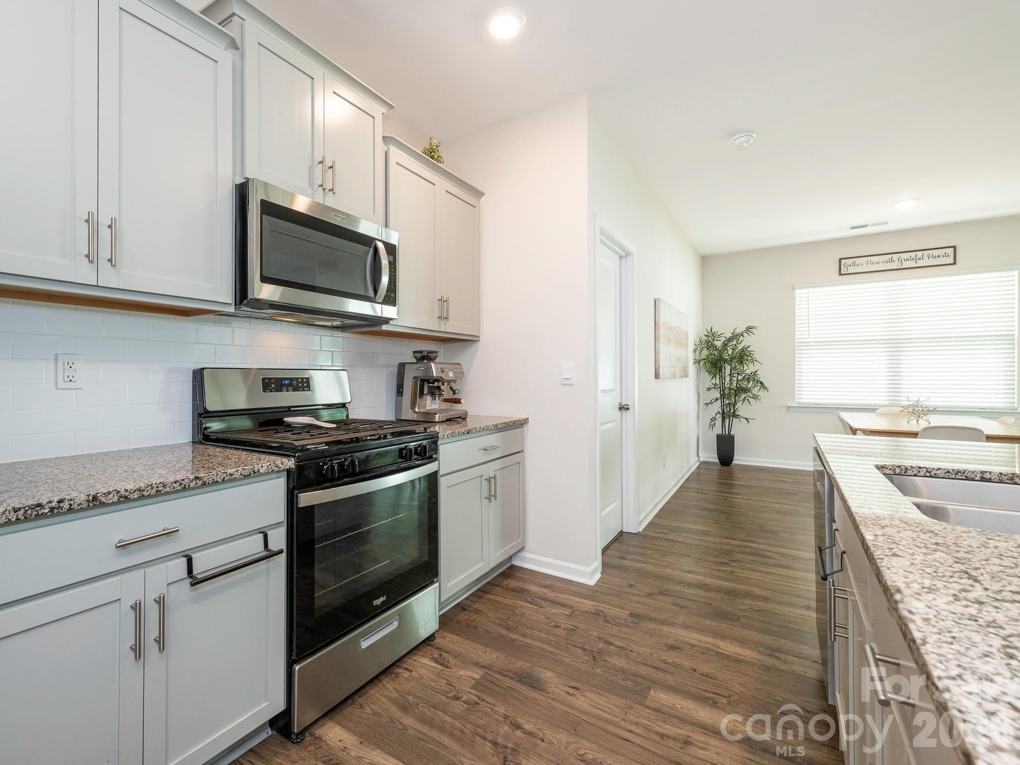 3649 Azalea Rdg Drive Mount Holly, NC 28120 - Photo 21 of 37 a kitchen with stainless steel appliances granite countertop a stove top oven a sink dishwasher and microwave with wooden floor