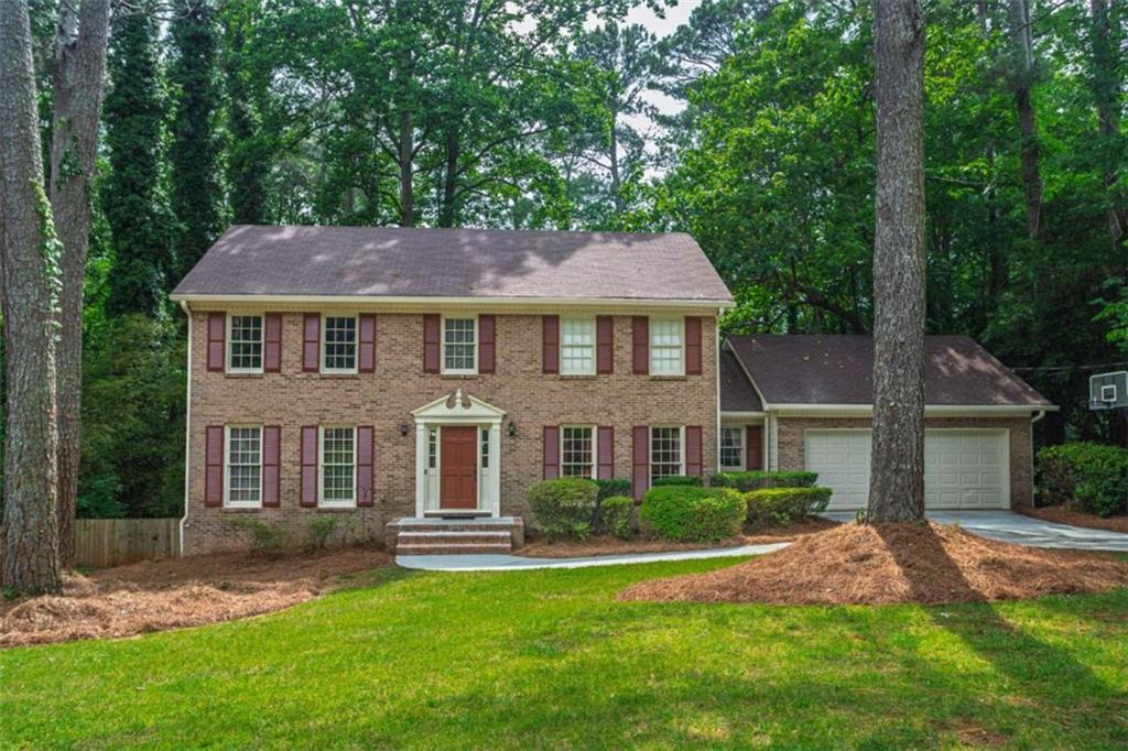 3838 Hunting Ridge Drive Southwest Lilburn, GA 30047 - Photo 1 of 56 a front view of a house with a garden and plants
