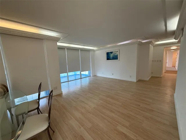 an empty room with wooden floor and bench