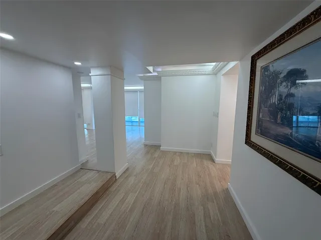 an empty room with wooden floor and a ceiling fan
