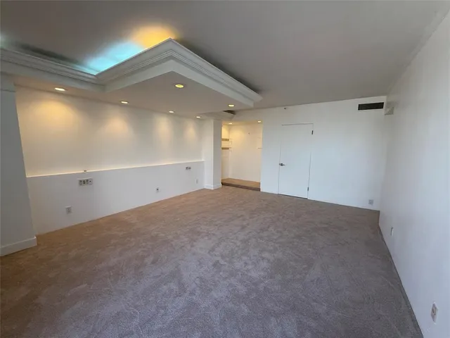 a view of an empty room with windows and stairs