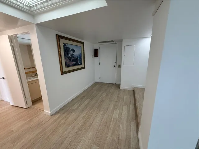 a view of a hallway with wooden floor and closet