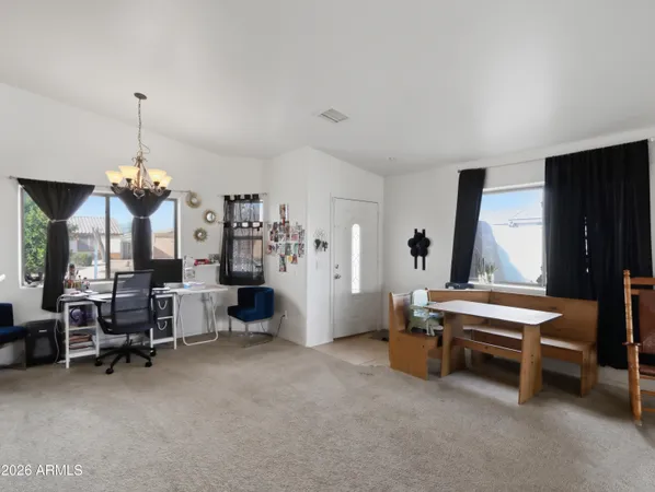 a living room with furniture a flat screen tv and a chandelier