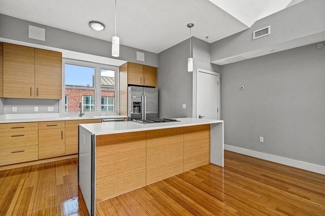 a large kitchen with stainless steel appliances granite countertop a stove a sink and a refrigerator