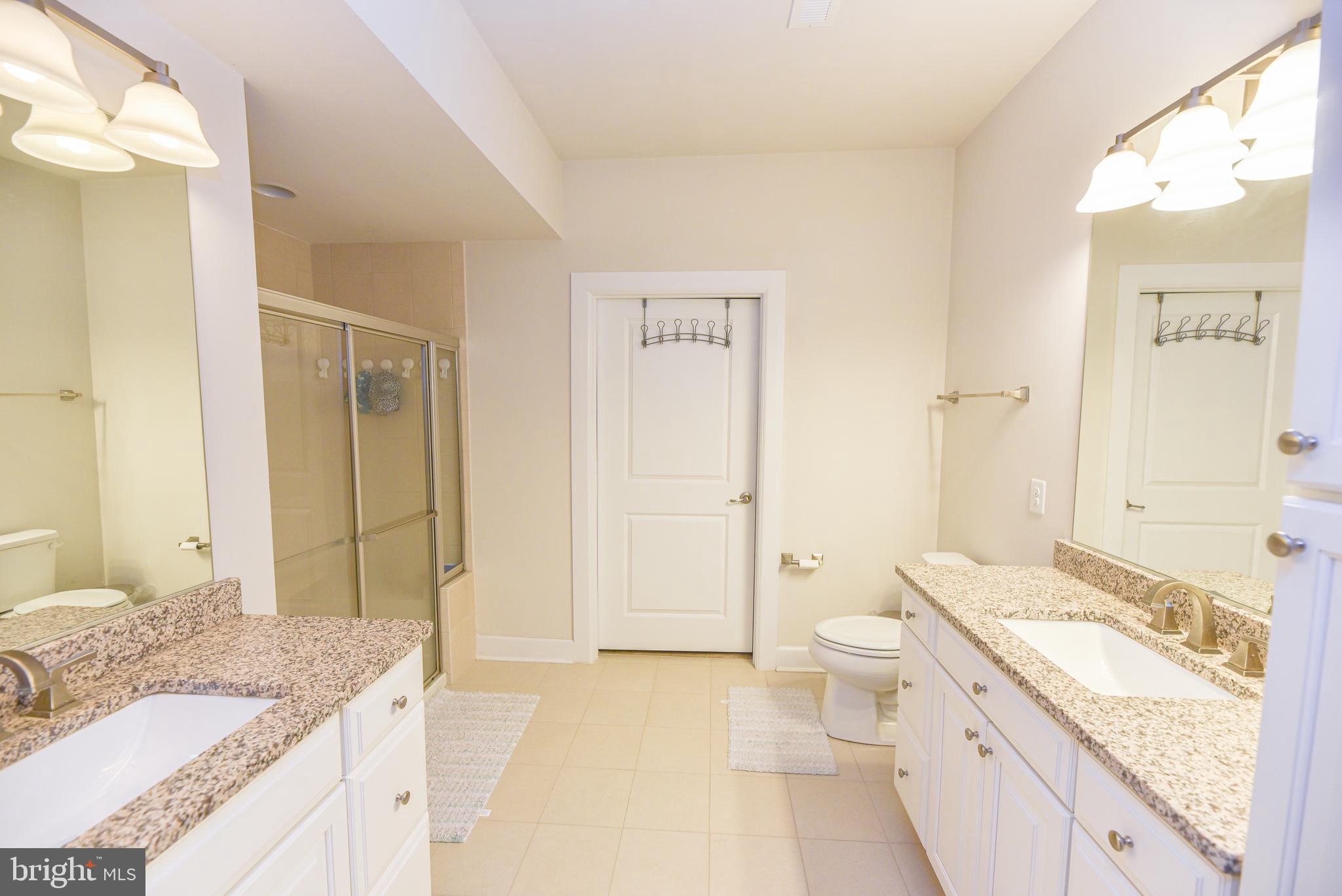 22379 Grebe Lane Ocean View, DE 19970 - Photo 21 of 41 a spacious bathroom with a granite countertop sink a toilet a mirror and shower