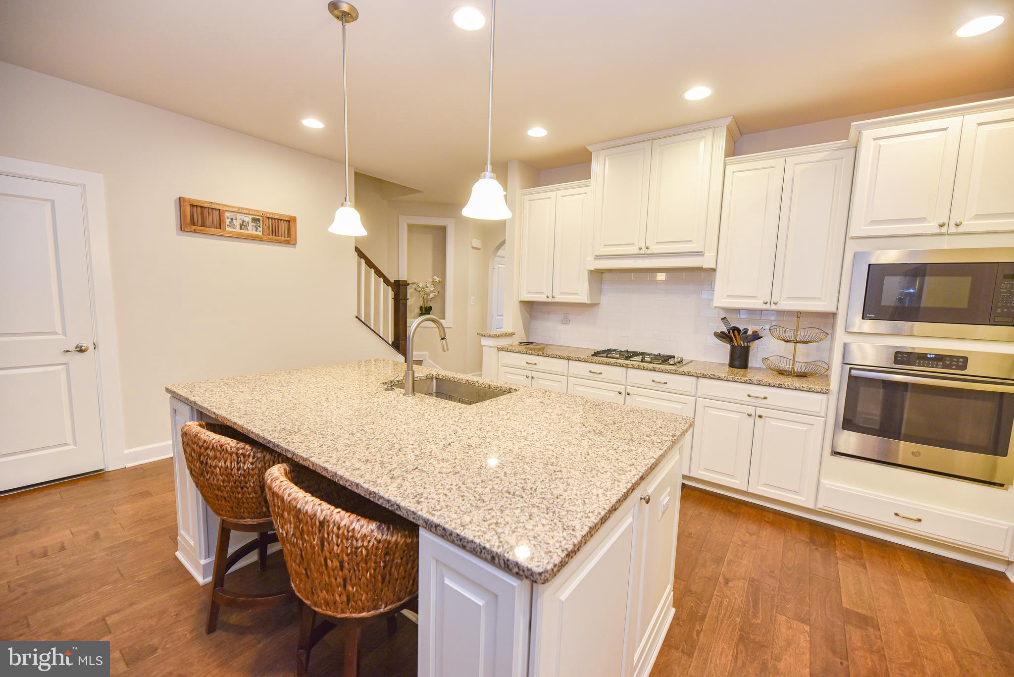 22379 Grebe Lane Ocean View, DE 19970 - Photo 6 of 41 a kitchen with stainless steel appliances granite countertop a sink a stove and a wooden floors
