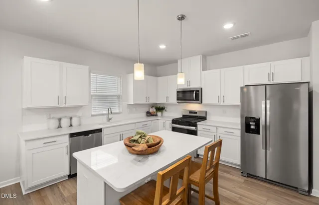 a kitchen with a table chairs refrigerator and microwave