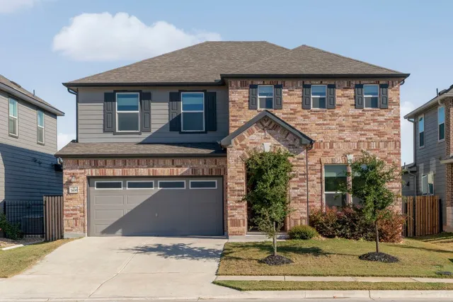 a front view of a house with a yard and garage