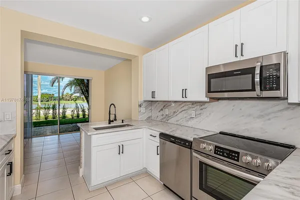 a kitchen with white cabinets and appliances