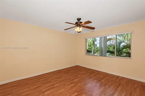 a view of a big room with wooden floor and a window