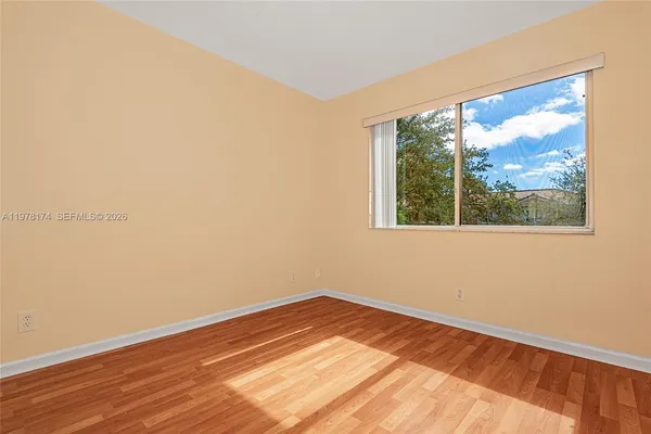 a view of a room with wooden floor and a window