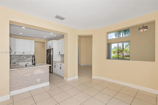 a large space with a large window and kitchen view