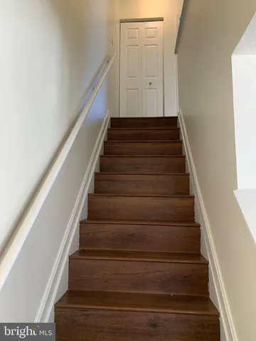 an empty room with wooden floor fireplace and windows