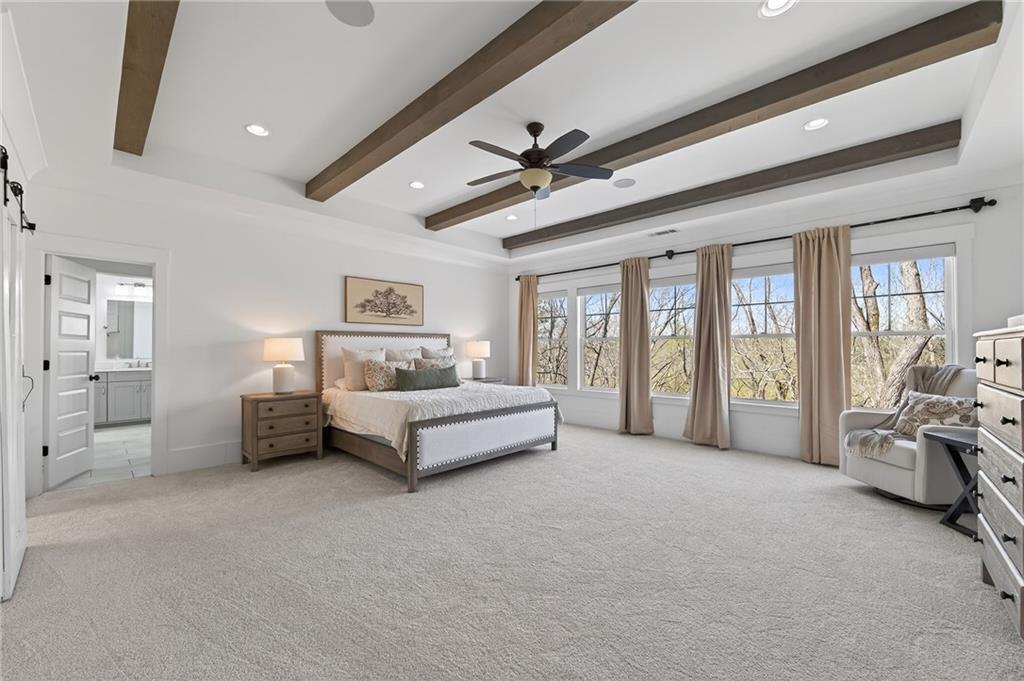 554 Gables Run Milton, GA 30004 - Photo 17 of 47 a spacious bedroom with a bed couch and a large window