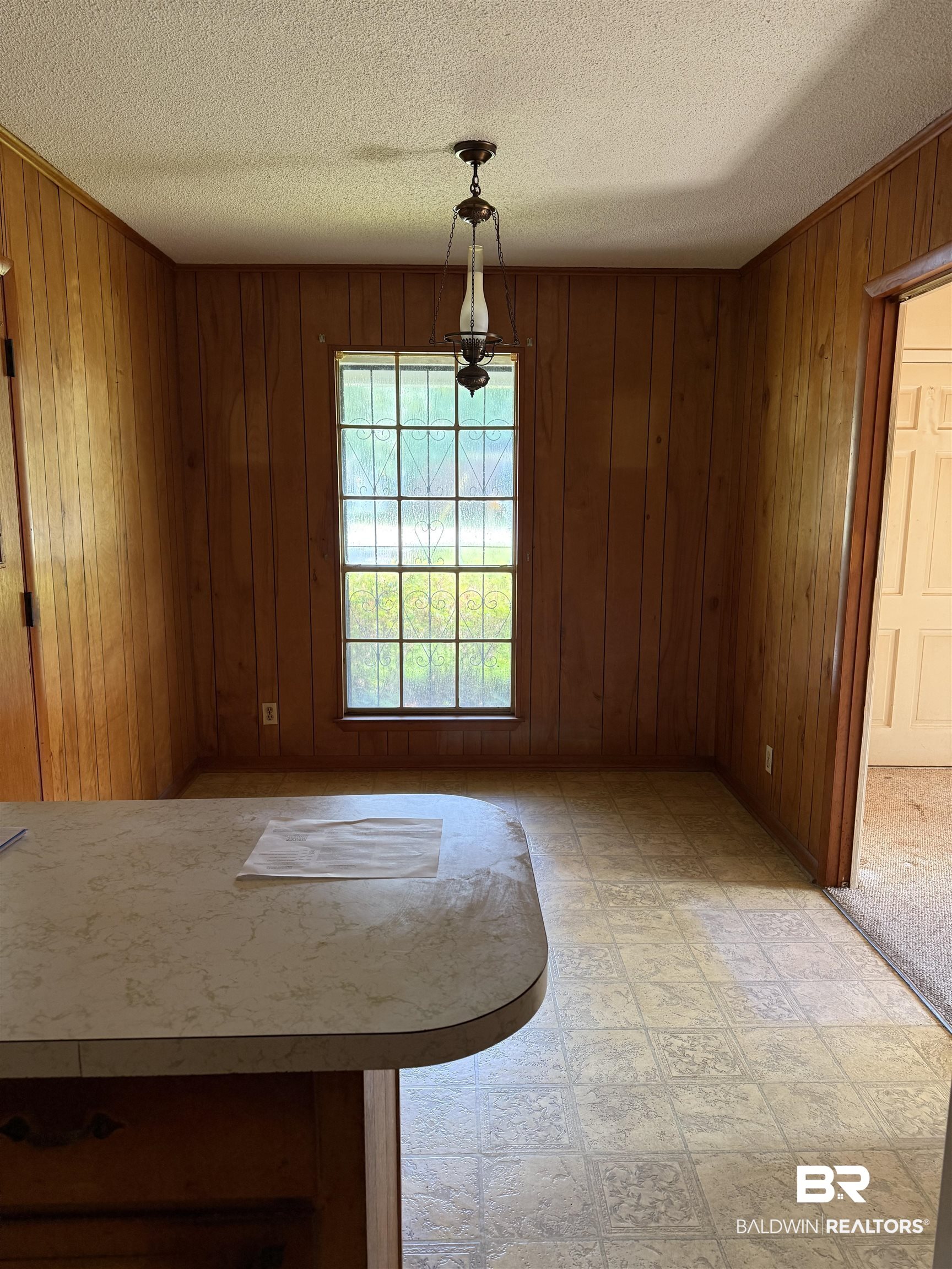 607 West Lee Street Mobile, AL 36611 - Photo 4 of 11 Unfurnished dining area featuring a textured ceiling, wood walls, and light flooring