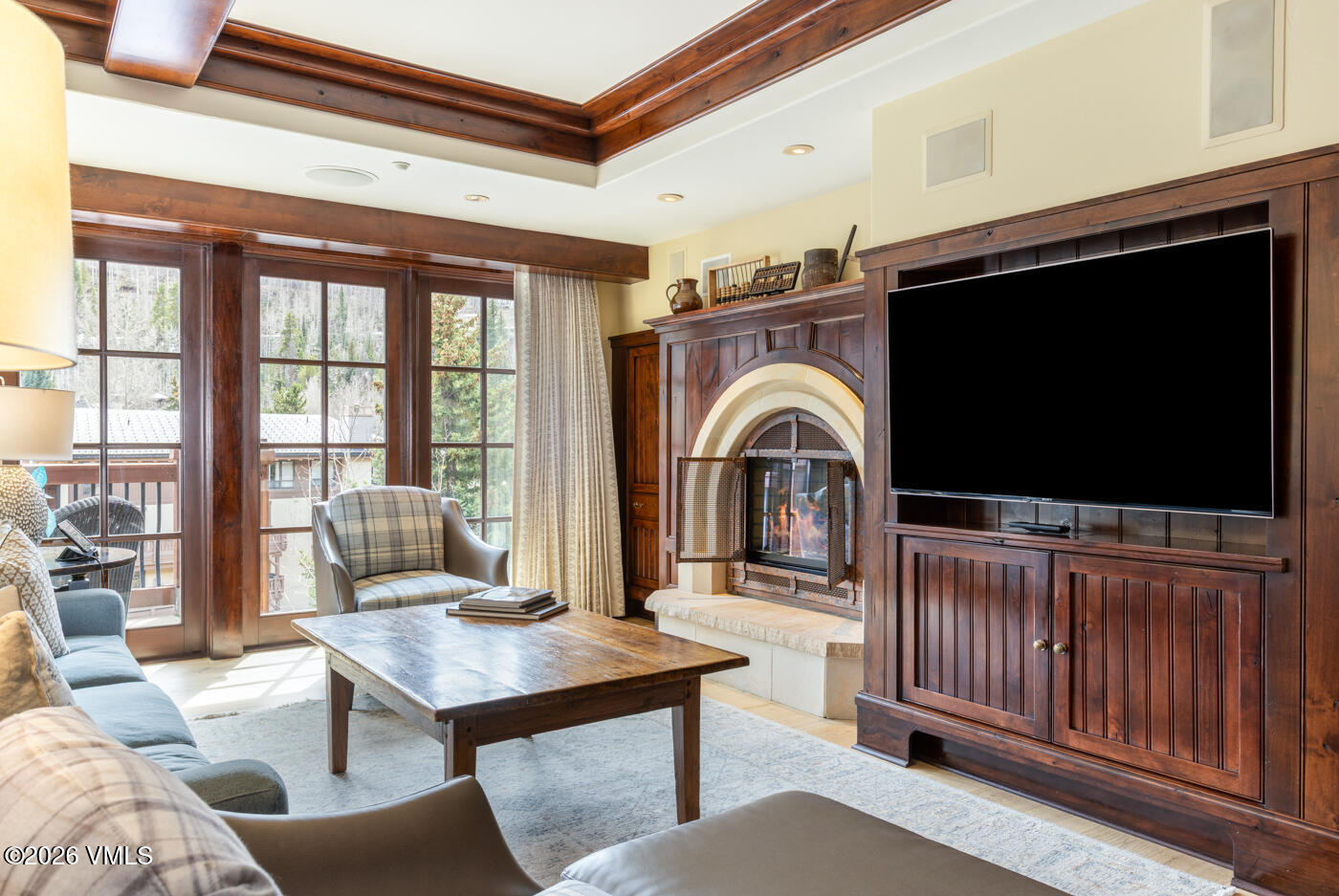 1 Willow Bridge Road, Unit 33 Vail, CO 81657 - Photo 2 of 40 a living room with furniture a flat screen tv and a floor to ceiling window